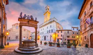 Piazza medievale con pozzo e leoni, torre dell'orologio. Un assaggio di cosa vedere in alta Toscana.