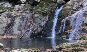 Cascate di Pontremoli in autunno, con foglie cadute che adornano rocce e specchi d'acqua.