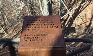 Targa arrugginita sul monte Falterona con citazione di Dante Alighieri sul fiume che nasce qui.