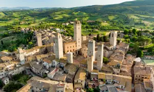 San Gimignano, con le sue torri medievali che svettano tra i tetti, incanta in un paesaggio collinare toscano.