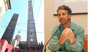 Le torri Asinelli e Garisenda a Bologna, con una cupola in mezzo, e un uomo che parla al microfono.