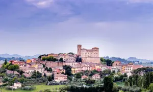Borgo medievale arroccato sulla collina nella valle del Rubicone, con un imponente castello e case colorate.