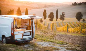 Un furgone camper attrezzato in un vigneto al tramonto, perfetto per un'avventura di **Toscana in camper 3 giorni**.