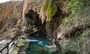 Le cascate di Labante creano un'oasi verde con acqua cristallina e rocce ricoperte di muschio. Un sentiero con staccionata in legno invita all'esplorazione.