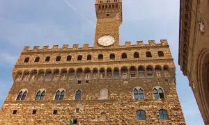 Palazzo Vecchio, simbolo di Firenze medievale, con la sua torre imponente e gli stemmi araldici.