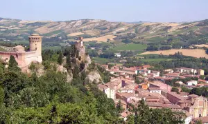 Un borgo medievale con un castello domina il paesaggio collinare di Brisighella, Italia.