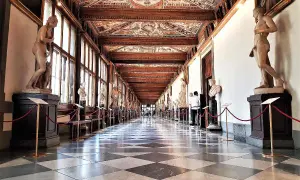 Corridoio degli Uffizi con statue classiche e soffitto affrescato. Un assaggio di cosa vedere agli Uffizi, tra capolavori e architettura.