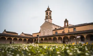 Cortile con portico ad archi e campanile, immerso in un prato fiorito. Un luogo sereno sul monte Senario.