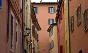 Vicoli colorati, perfetti per gite fuori porta da Bologna. Case con persiane verdi e lampioni antichi creano un'atmosfera suggestiva.