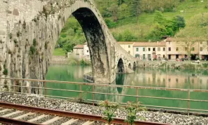 Ponte del Diavolo a Borgo a Mozzano, con case colorate e il fiume Serchio.