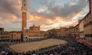 Piazza del Campo a Siena, gremita di spettatori in attesa del Palio. Cos'è il Palio di Siena? Una corsa di cavalli storica.