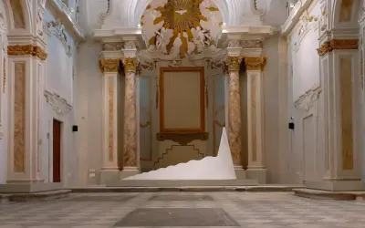 Installazione moderna in un ambiente storico, tra i musei di Livorno. Una scultura bianca a forma di onda domina la scena.