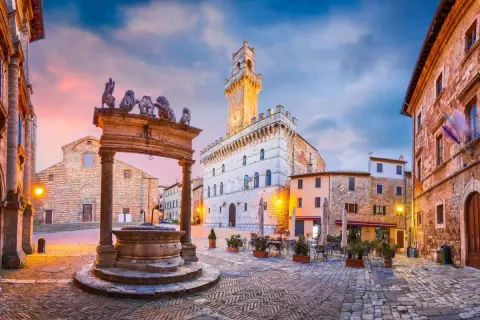 Piazza medievale con pozzo e leoni, torre dell'orologio. Un assaggio di cosa vedere in alta Toscana.