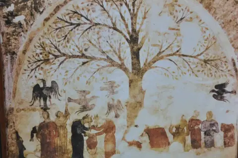 Antico affresco a Massa Marittima: un albero della vita con figure umane e uccelli, forse un racconto di antiche tradizioni.