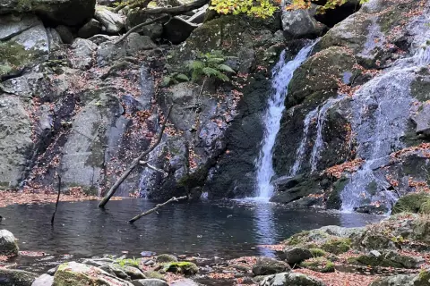 Cascate di Pontremoli in autunno, con foglie cadute che adornano rocce e specchi d'acqua.