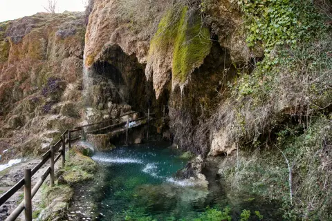 Le cascate di Labante creano un'oasi verde con acqua cristallina e rocce ricoperte di muschio. Un sentiero con staccionata in legno invita all'esplorazione.