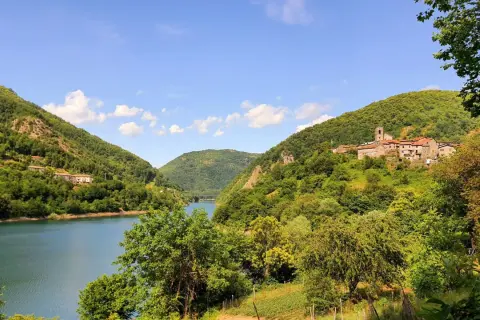 Villaggio tra colline verdi e lago, ideale per escursioni apuane facili.