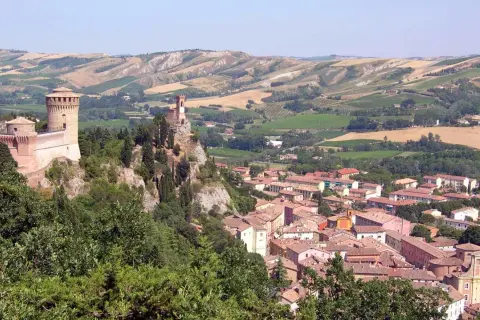 Un borgo medievale con un castello domina il paesaggio collinare di Brisighella, Italia.