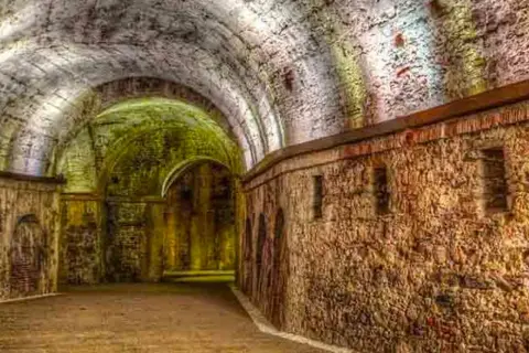 Antiche volte e mura in pietra di una domus romana a Lucca, illuminate da luci soffuse che creano un'atmosfera suggestiva.