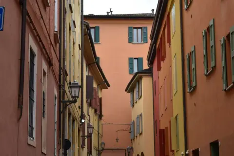 Vicoli colorati, perfetti per gite fuori porta da Bologna. Case con persiane verdi e lampioni antichi creano un'atmosfera suggestiva.