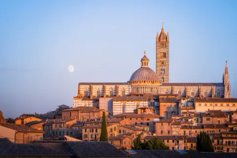 La luna illumina i tetti di Siena, offrendo uno dei suoi migliori punti panoramici.