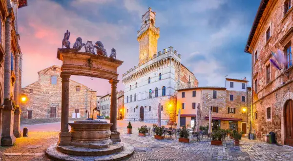 Piazza medievale con pozzo e leoni, torre dell'orologio. Un assaggio di cosa vedere in alta Toscana.