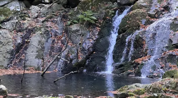 Cascate di Pontremoli in autunno, con foglie cadute che adornano rocce e specchi d'acqua.