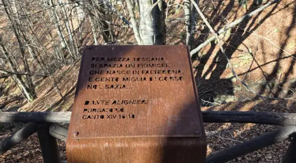 Targa arrugginita sul monte Falterona con citazione di Dante Alighieri sul fiume che nasce qui.