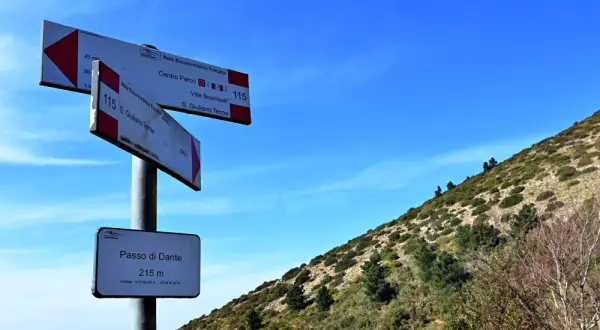 Segnaletica escursionistica sul **Monte Pisano**, indica il Passo di Dante a 215 m e sentieri per S. Giuliano Terme.