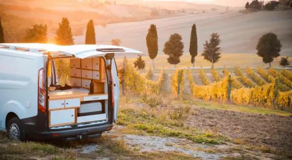 Un furgone camper attrezzato in un vigneto al tramonto, perfetto per un'avventura di **Toscana in camper 3 giorni**.
