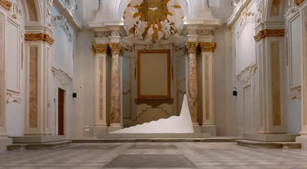Installazione moderna in un ambiente storico, tra i musei di Livorno. Una scultura bianca a forma di onda domina la scena.