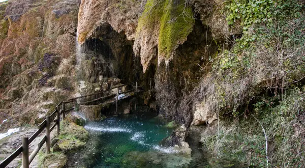 Le cascate di Labante creano un'oasi verde con acqua cristallina e rocce ricoperte di muschio. Un sentiero con staccionata in legno invita all'esplorazione.