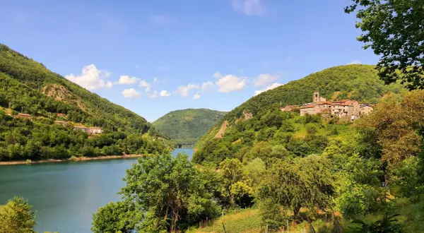 Villaggio tra colline verdi e lago, ideale per escursioni apuane facili.