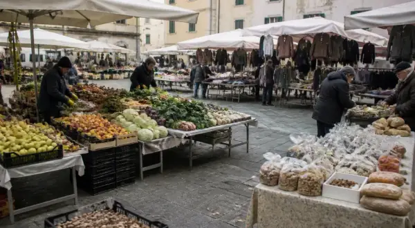 Mercato all'aperto a Marina di Massa con bancarelle di frutta, verdura e abbigliamento.