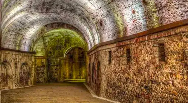 Antiche volte e mura in pietra di una domus romana a Lucca, illuminate da luci soffuse che creano un'atmosfera suggestiva.