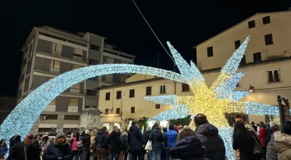 Luci natalizie scintillanti illuminano il poggibonsi markt, creando un'atmosfera magica tra la folla.