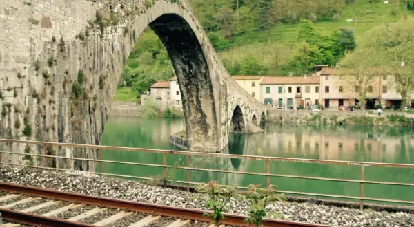 Ponte del Diavolo a Borgo a Mozzano, con case colorate e il fiume Serchio.