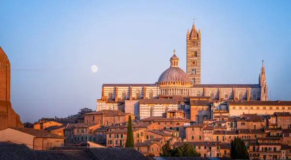 La luna illumina i tetti di Siena, offrendo uno dei suoi migliori punti panoramici.