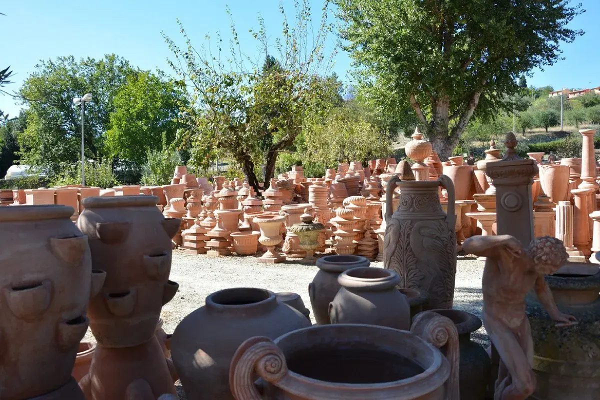 Vasta esposizione di terracotta a Impruneta, Firenze: vasi, statue e decorazioni da giardino sotto il sole toscano.