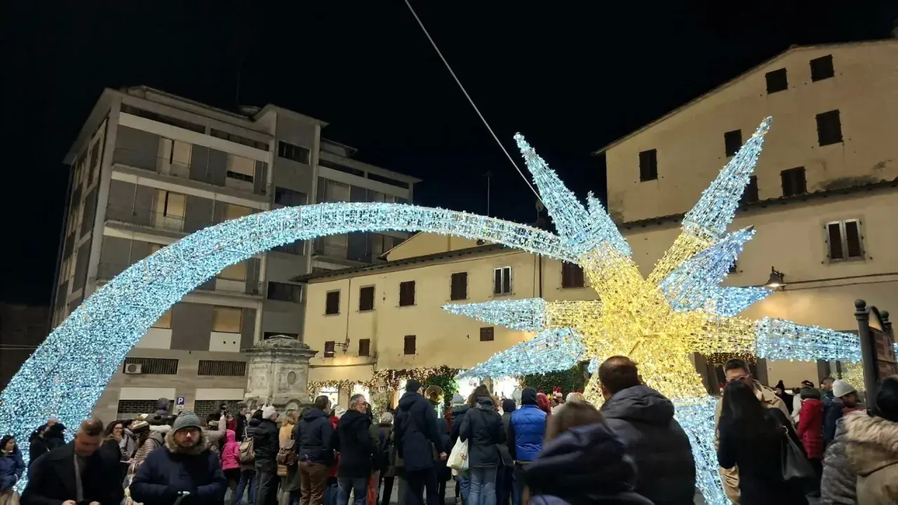 Luci natalizie scintillanti illuminano il poggibonsi markt, creando un'atmosfera magica tra la folla.