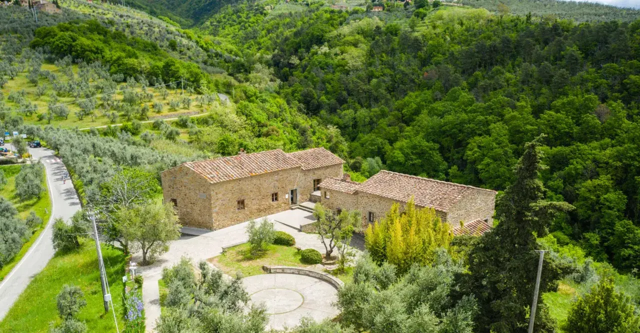 Casolare in pietra immerso nel verde della campagna di Vinci, Toscana, tra ulivi e boschi rigogliosi.