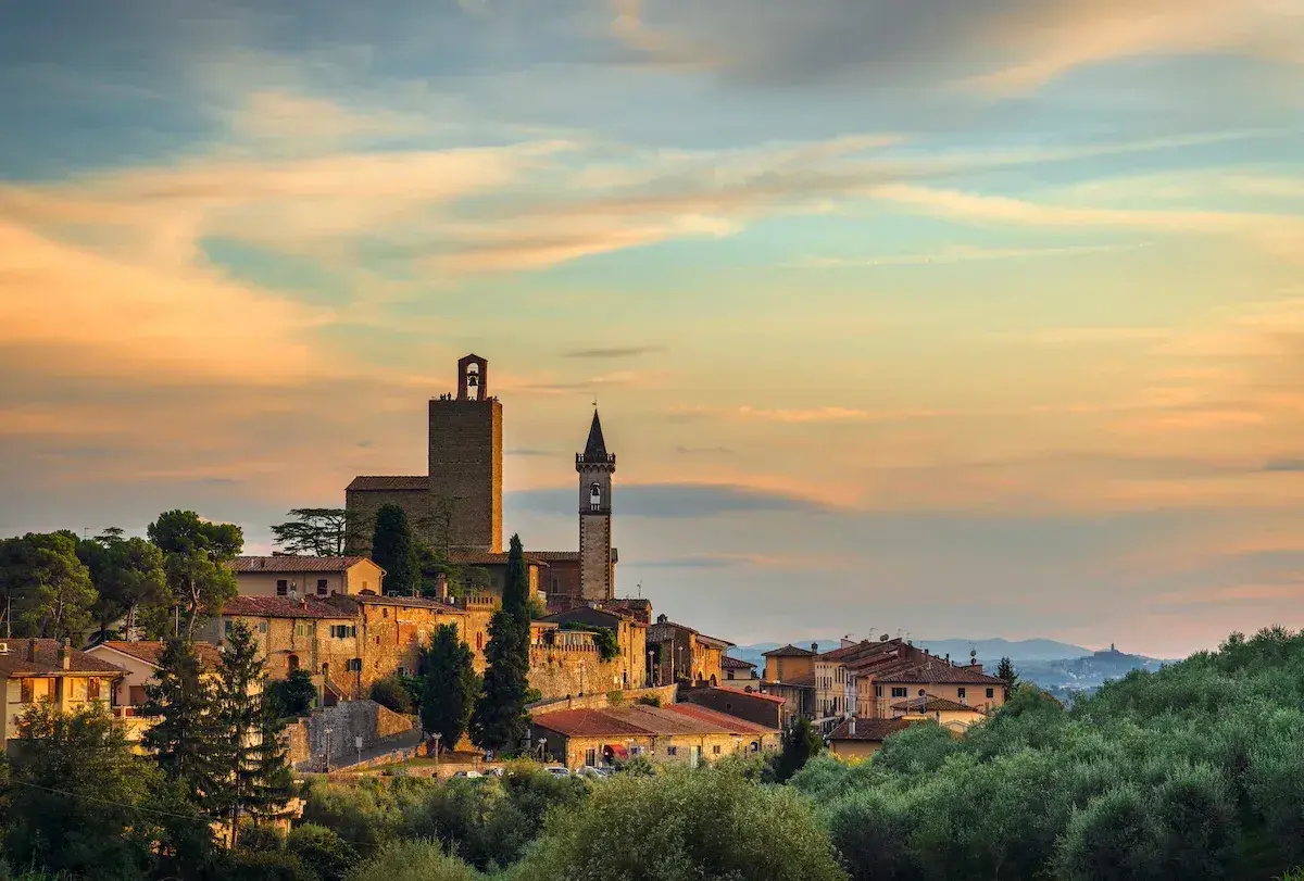 Borgo medievale al tramonto, con torri e case in pietra. Ecco cosa vedere a Vinci, un gioiello toscano tra ulivi secolari.