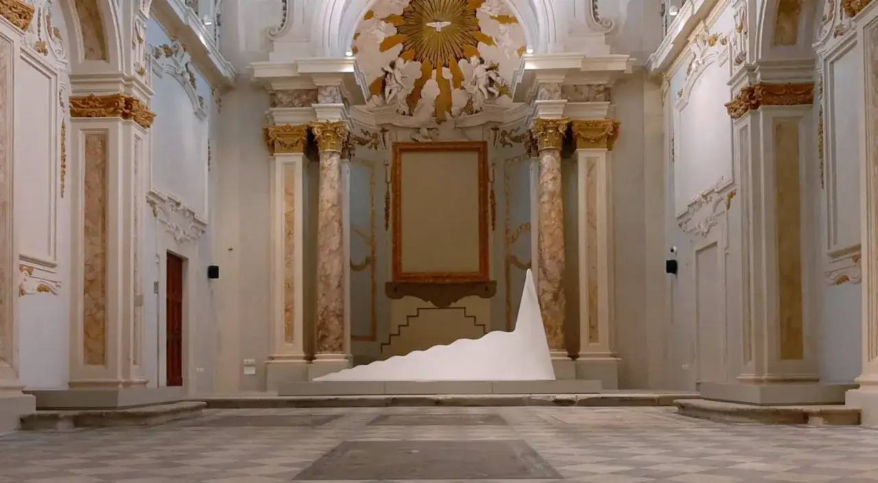 Installazione moderna in un ambiente storico, tra i musei di Livorno. Una scultura bianca a forma di onda domina la scena.