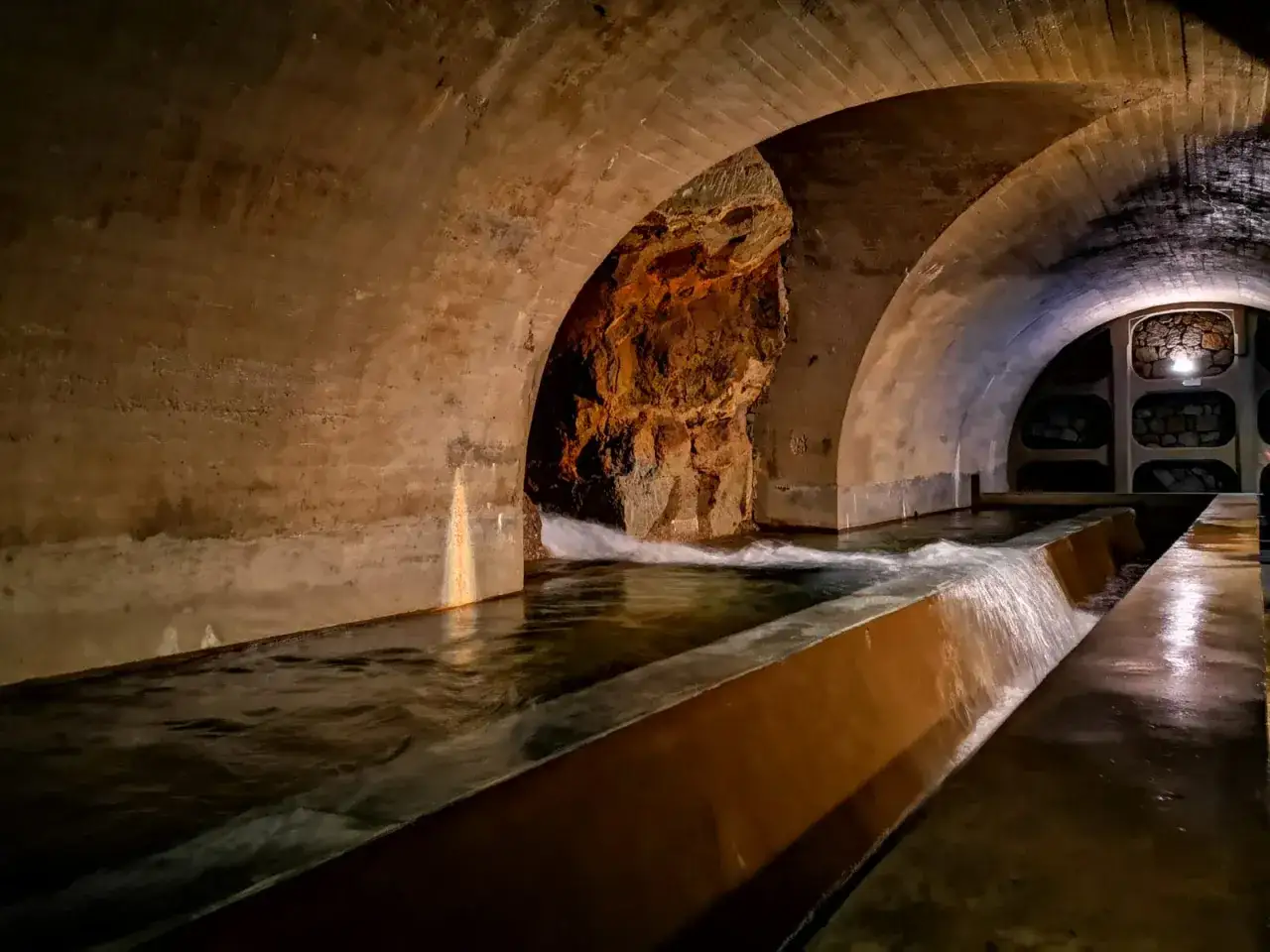 Acquedotto sotterraneo a Vivo d'Orcia, un'affascinante cosa da vedere. L'acqua scorre sotto archi di cemento, rivelando la roccia grezza.