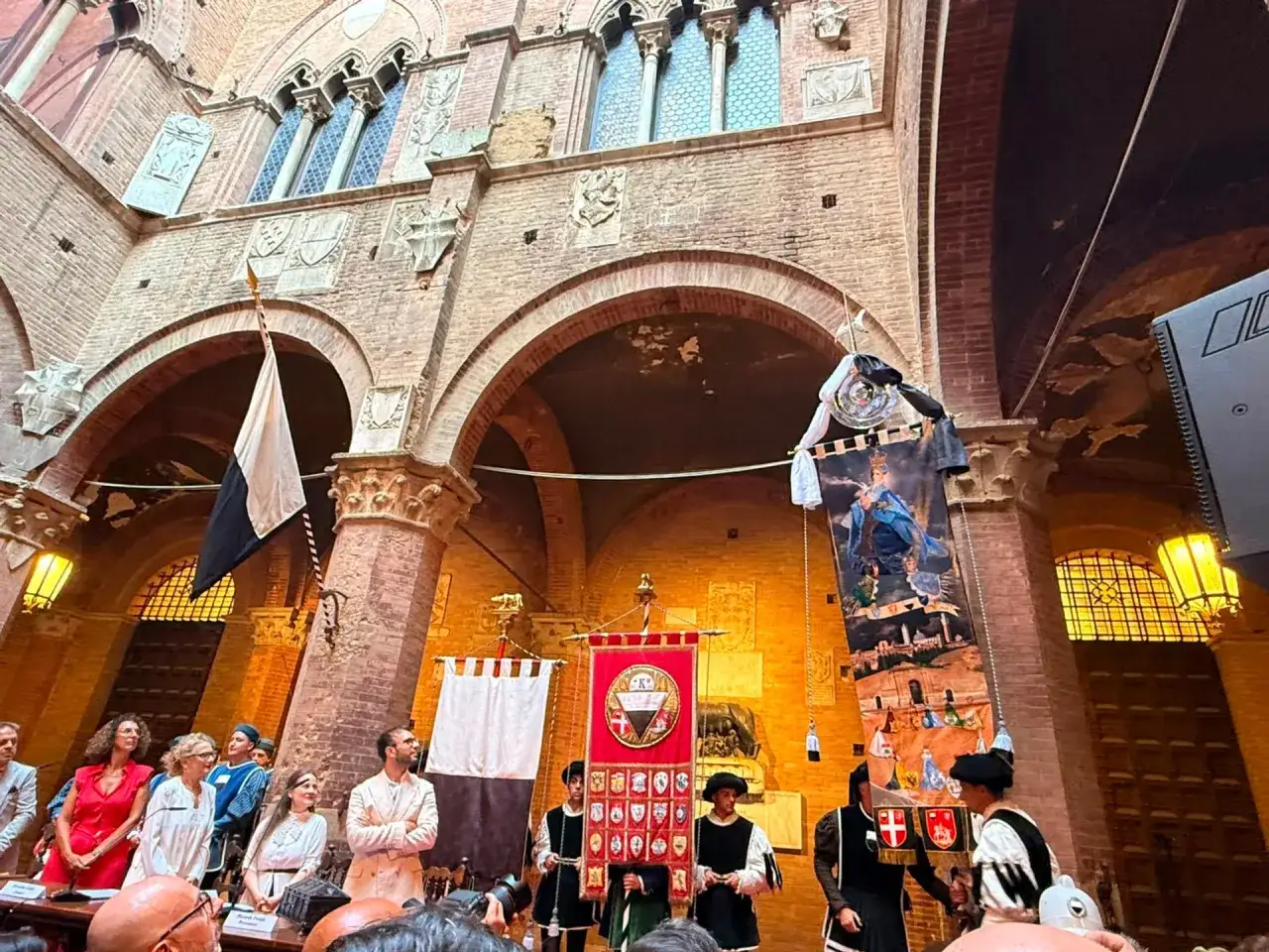 Sfilata storica a Siena con bandiere e costumi d'epoca. Un evento che celebra il Palio di Siena.