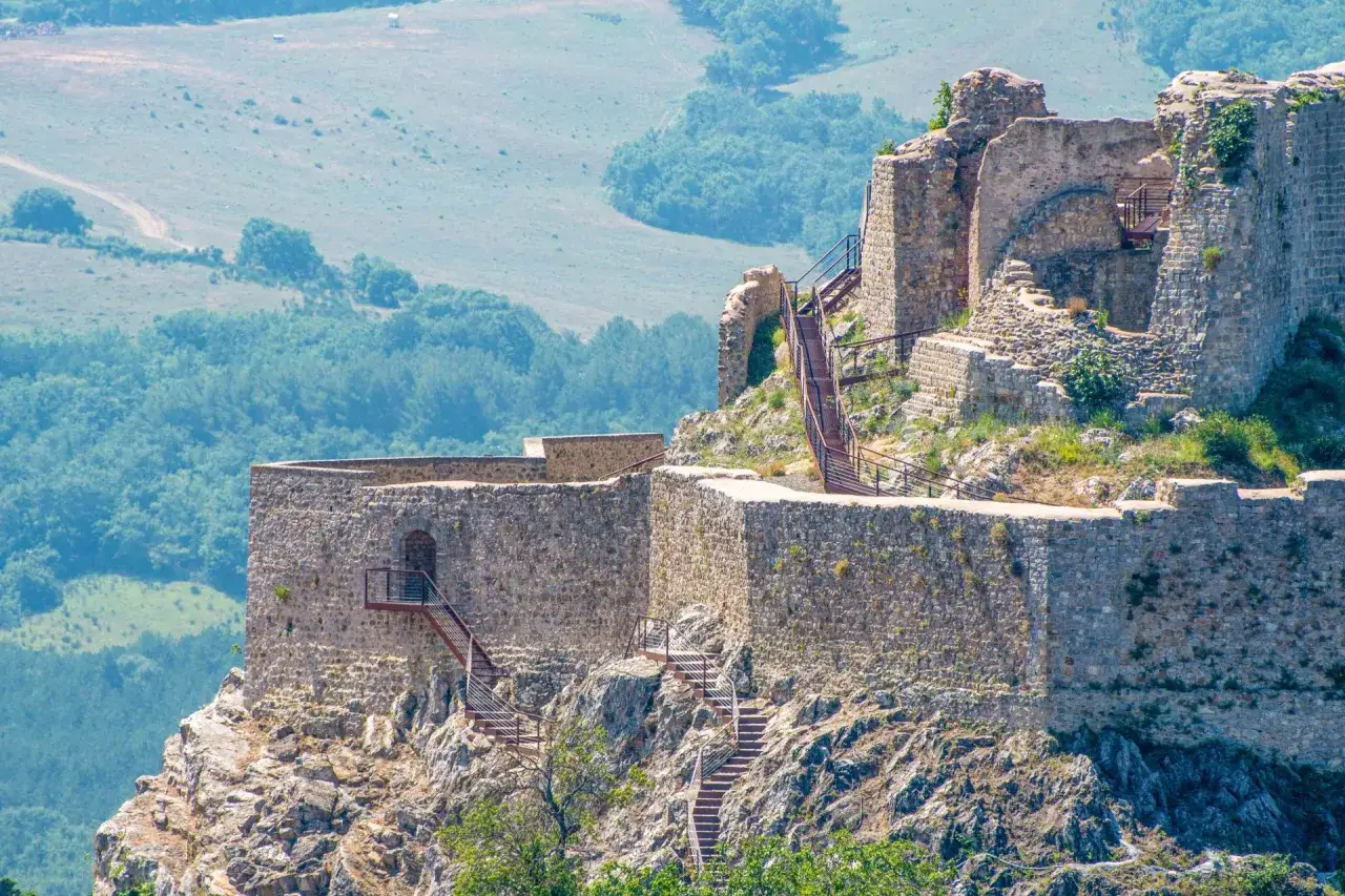 La Rocca Aldobrandesca a Castiglione d'Orcia, con le sue mura in pietra e le scale metalliche, domina il paesaggio collinare.