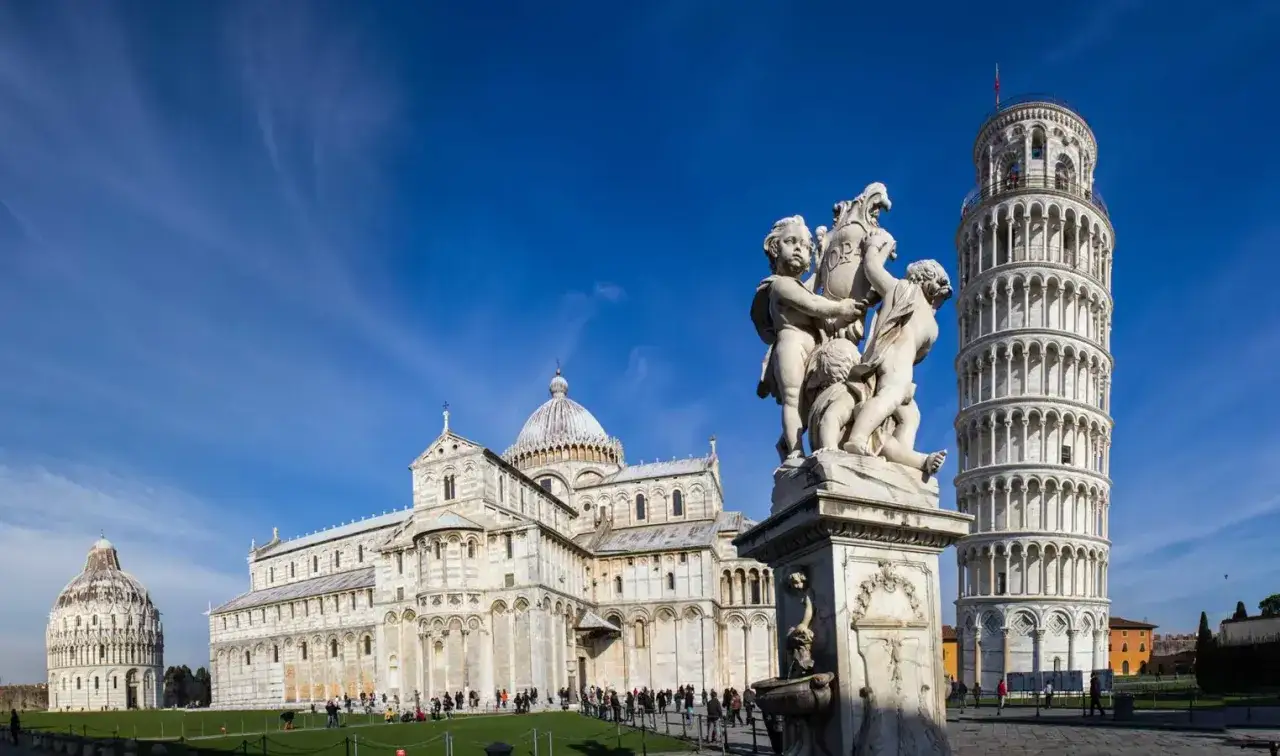 La Torre di Pisa e il Duomo, tra i più celebri monumenti della Toscana, sotto un cielo azzurro.