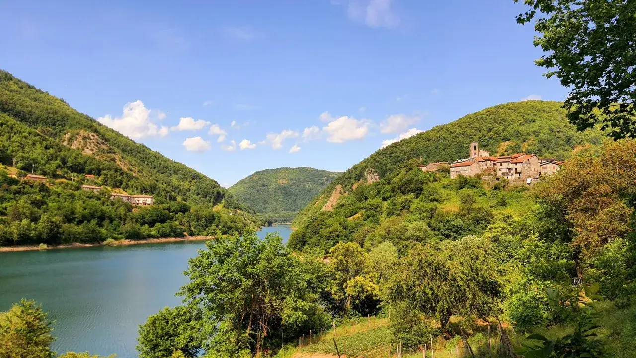 Villaggio tra colline verdi e lago, ideale per escursioni apuane facili.