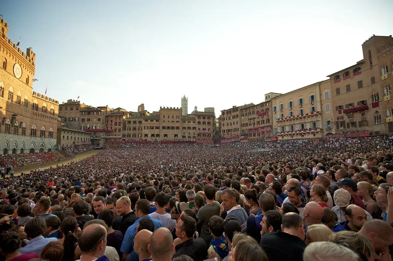 Folla immensa in Piazza del Campo a Siena, in attesa del Palio. L'atmosfera è elettrica, un vero evento storico.