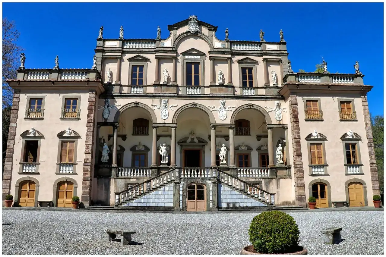 La Villa Mansi, con la sua imponente facciata e le statue, si erge maestosa sotto un cielo azzurro.
